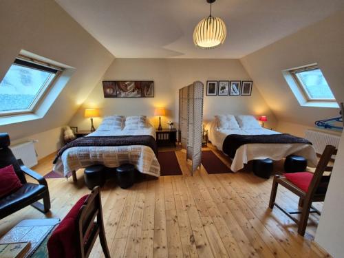 a bedroom with two beds and a chandelier at Ti Ar Skol, chambre d'hôtes in Huelgoat