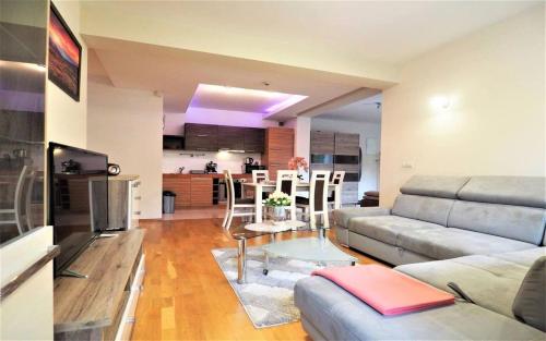 a living room with a couch and a table at VIP Apartamenty Carmelove in Zakopane
