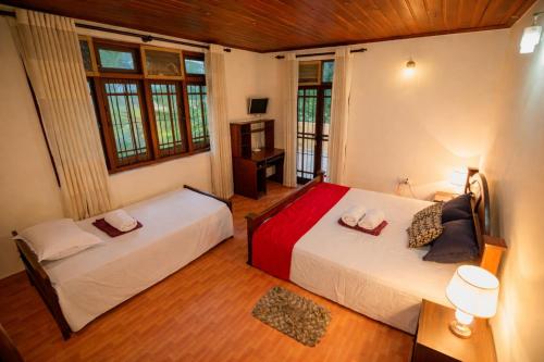 two beds in a room with two windows at Airport Serenity Villa - Near Colombo Airport in Katunayaka