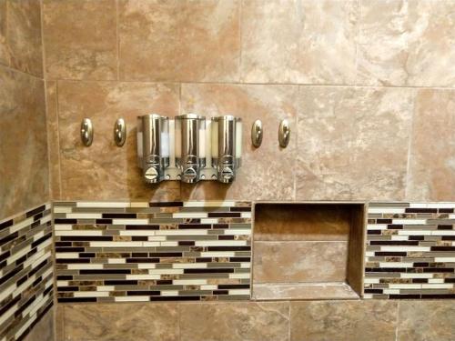a shower with brown tile and silver dividers at Unit 17 Large 1 Bed 1 Bath Condo Ocean Views in Pahala
