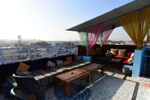 a balcony with a couch and tables on a roof at Yogis Guest House in Jodhpur