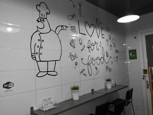 a wall with a drawing of a chef on it at Diagonal House Hostel in Barcelona