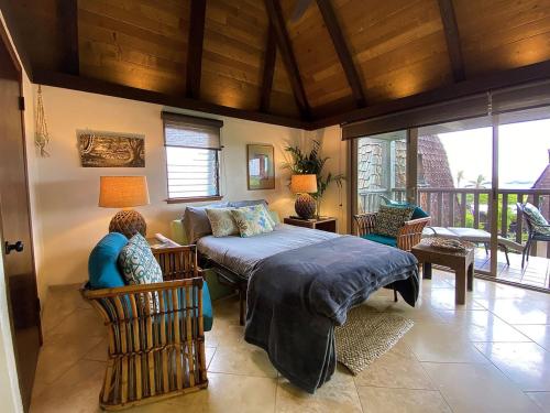 a bedroom with a bed and a living room at 70 Pogs Place at Black Sand Beach in Pahala