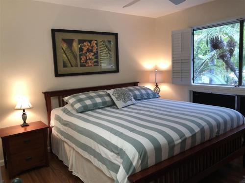 a bedroom with a bed and two lamps and a window at 56 One Bedroom One Bath with Ocean Views in Pahala