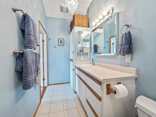 a bathroom with a sink and a mirror at Honu Harbor with Pool on Golf Course in Naalehu