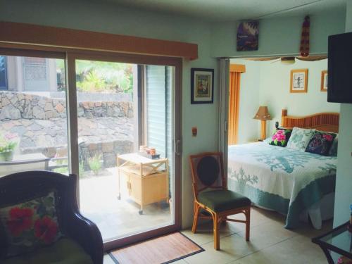 a bedroom with a bed and a sliding glass door at Unit 25 Hula Hut Best Value in Pahala