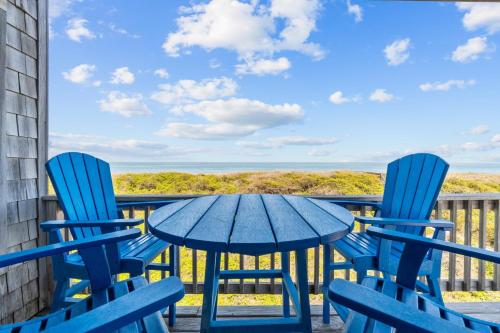 a table and chairs on a balcony with a view of the ocean at 2410 - Come Sail Away in Duck