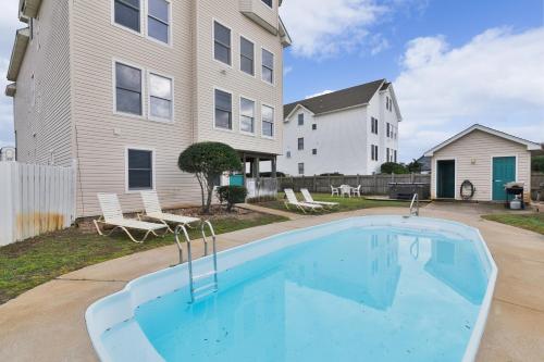 a swimming pool in front of a house at 5195 - Captain's Choice in Kill Devil Hills