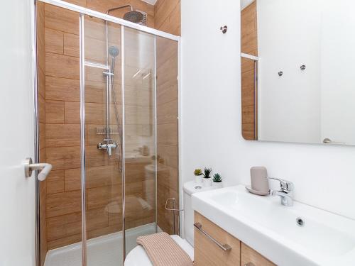 a bathroom with a shower and a toilet and a sink at Akisol Olhão Sweet in Olhão
