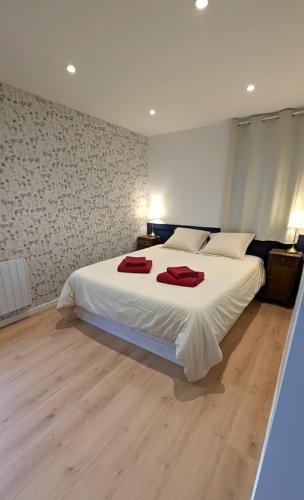 a bedroom with a large bed with two red towels on it at Les Misstinguettes in Hyenville