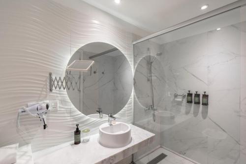 ein Badezimmer mit Waschbecken und Dusche mit Spiegel in der Unterkunft The Hub Urban Hotel in Asunción