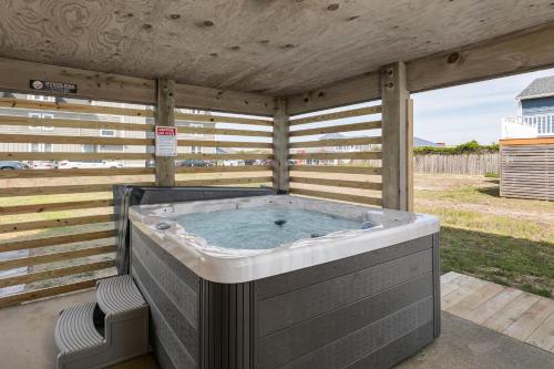 a large hot tub sitting on a patio with two chairs at 4740 - August's Summer Place in Kitty Hawk Beach
