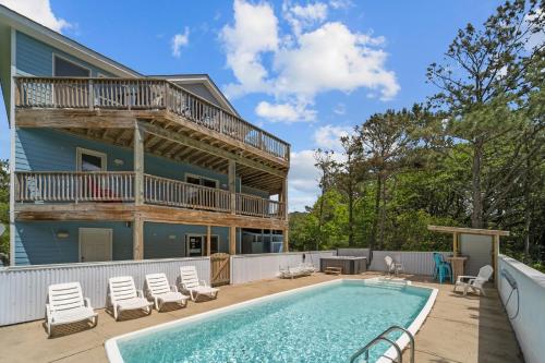a house with a swimming pool and a balcony at 1090 - Catch Me N Corolla in Corolla