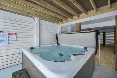 a jacuzzi tub in a building with a sign at 4918 - Stress Less in Kitty Hawk