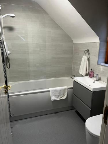 a bathroom with a white tub and a sink at Tully Mill Cottages in Bellanaleck