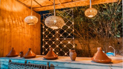 un gruppo di vasi di rame su un tavolo con luci di Le Bled Ferme a Marrakech