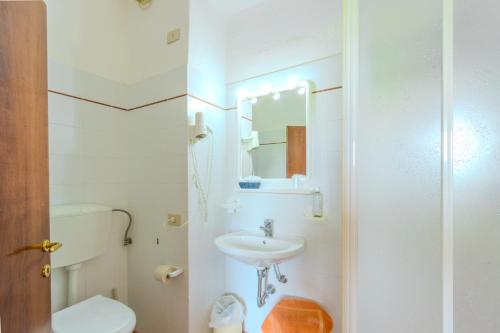 a white bathroom with a toilet and a sink at B&B La Bufalona - Pool & Relax in Massa Marittima