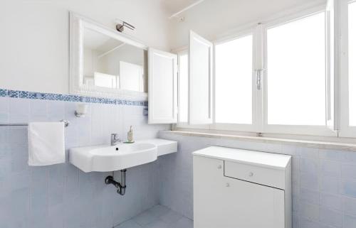 a white bathroom with a sink and a mirror at San Paolo Apartment in Pisa