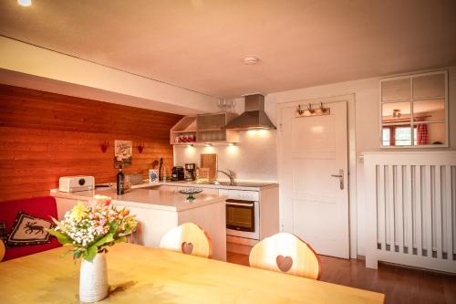 a kitchen with a table with a vase of flowers on it at Landhaus Thanner in Ofterschwang