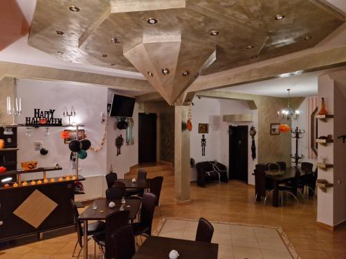 a restaurant with wooden ceilings and tables and chairs at Casa Nobilă in Bran