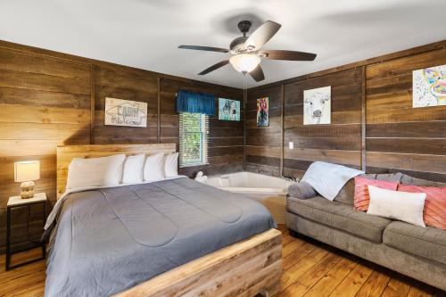 a bedroom with a bed and a couch at Private Mountain Nook with Jacuzzi - Cabin 6 in Fancy Gap