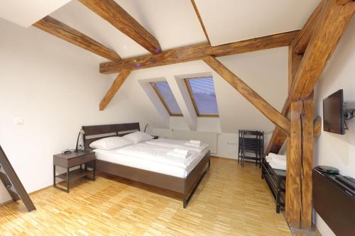 a bedroom with a bed and a desk and windows at AMS Rooms in Ljubljana