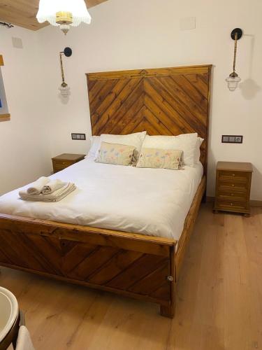 a bedroom with a large bed with a wooden headboard at Cal Sabater, la teva llar lluny de casa in Preixana
