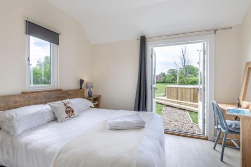 a bedroom with a bed and a large window at The Burrow in Biddenden