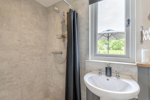 a bathroom with a sink and a window at The Burrow in Biddenden