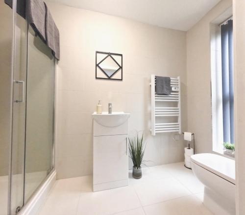 a white bathroom with a sink and a shower at C- Spacious En-Suite Room Sheffield Centre in Victoria