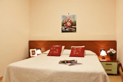 - une chambre avec un grand lit et des oreillers rouges dans l'établissement House Carla by Holiday World, à Albisola Superiore