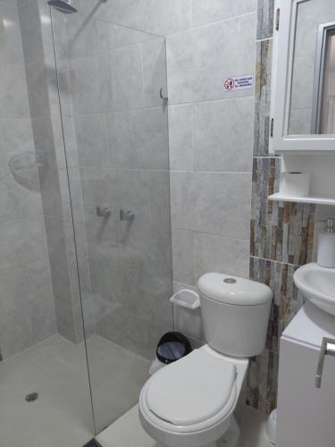 a bathroom with a toilet and a glass shower at San antero hospedaje in San Antero