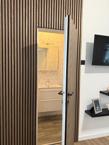 a door to a bathroom with a sink at Guesthouse Kurelic Rab in Kampor