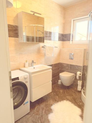a bathroom with a washing machine and a sink at Apartments Niko Novalja in Novalja