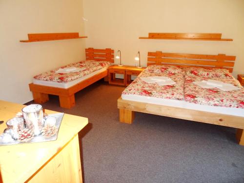 a room with two beds and two tables with candles at Penzion Bystrinka in Tale