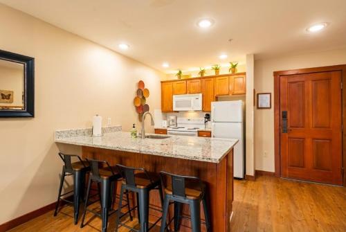a kitchen with a large island with bar stools at AS 326 No Resort Fee Pool-View Ski-InOut in Snowshoe