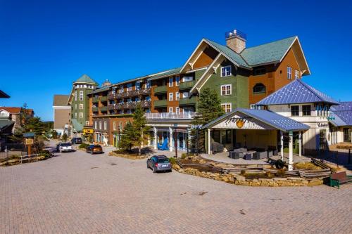 a large building with a car parked in a parking lot at HH207 Ski-inSki-out Condo Hot Tub Sleeps 4 in Snowshoe