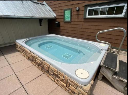 a jacuzzi tub in front of a house at HH207 Ski-inSki-out Condo Hot Tub Sleeps 4 in Snowshoe