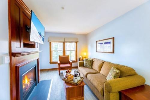 a living room with a couch and a fireplace at Lux Stay USA Pool view Crest Ski-inout Hot Tub AS241 in Snowshoe
