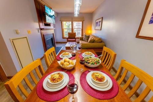 a dining room table with plates and bowls of food at Lux Stay USA Pool view Crest Ski-inout Hot Tub AS241 in Snowshoe
