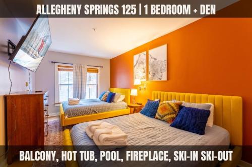 two beds in a room with an orange wall at Lux Stay USA Pool view Hearthstone Ski-inOut, AS125 1BRDen in Snowshoe