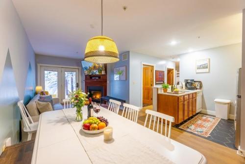 a kitchen and living room with a table with a bowl of fruit at Lux Stay USA Pool view Hearthstone Ski-inOut, AS125 1BRDen in Snowshoe