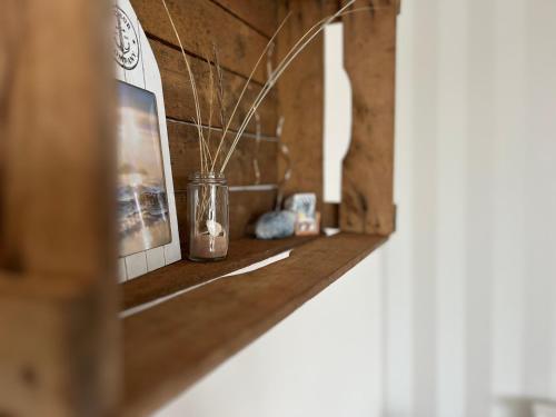 a room with a shelf with a jar and a picture at lüttjeseeblick13 in Nordstrand