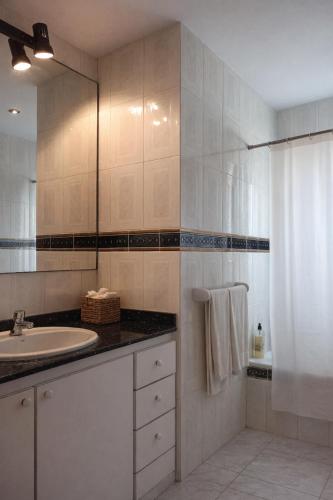 a white bathroom with a sink and a mirror at Vila Mimosa in Colonia de Sant Pere