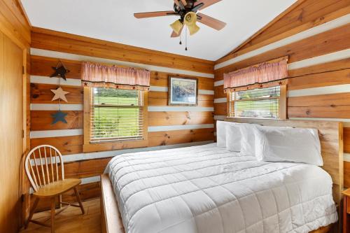 a bedroom with a bed and a ceiling fan at 2BR Cabin with Jacuzzi and Mountain Views - Cabin 5 in Fancy Gap