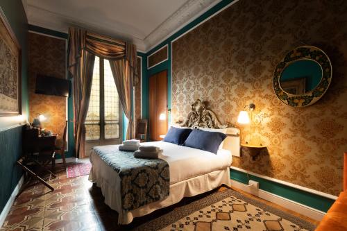 a bedroom with a large bed and a mirror at Casa della Contessa Art Guest House in Turin
