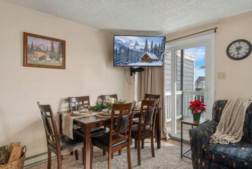 a dining room with a table and chairs and a tv at Snowshoe Ski-InSki-Out Steps to Ballhooter Lift Mountain Lodge Condo in Snowshoe