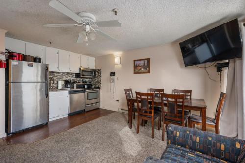 a kitchen and dining room with a table and a refrigerator at Snowshoe Ski-InSki-Out Steps to Ballhooter Lift Mountain Lodge Condo in Snowshoe
