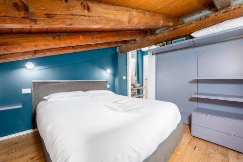 a bedroom with a white bed and a blue wall at Appartamento Elegante con 2 Camere nel Centro Storico di Bologna in Bologna
