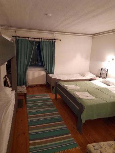 a bedroom with two beds and a rug at Wiikki Majatalo in Viitasaari
